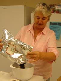 A co-op member measures out spices to distribute to fellow members.